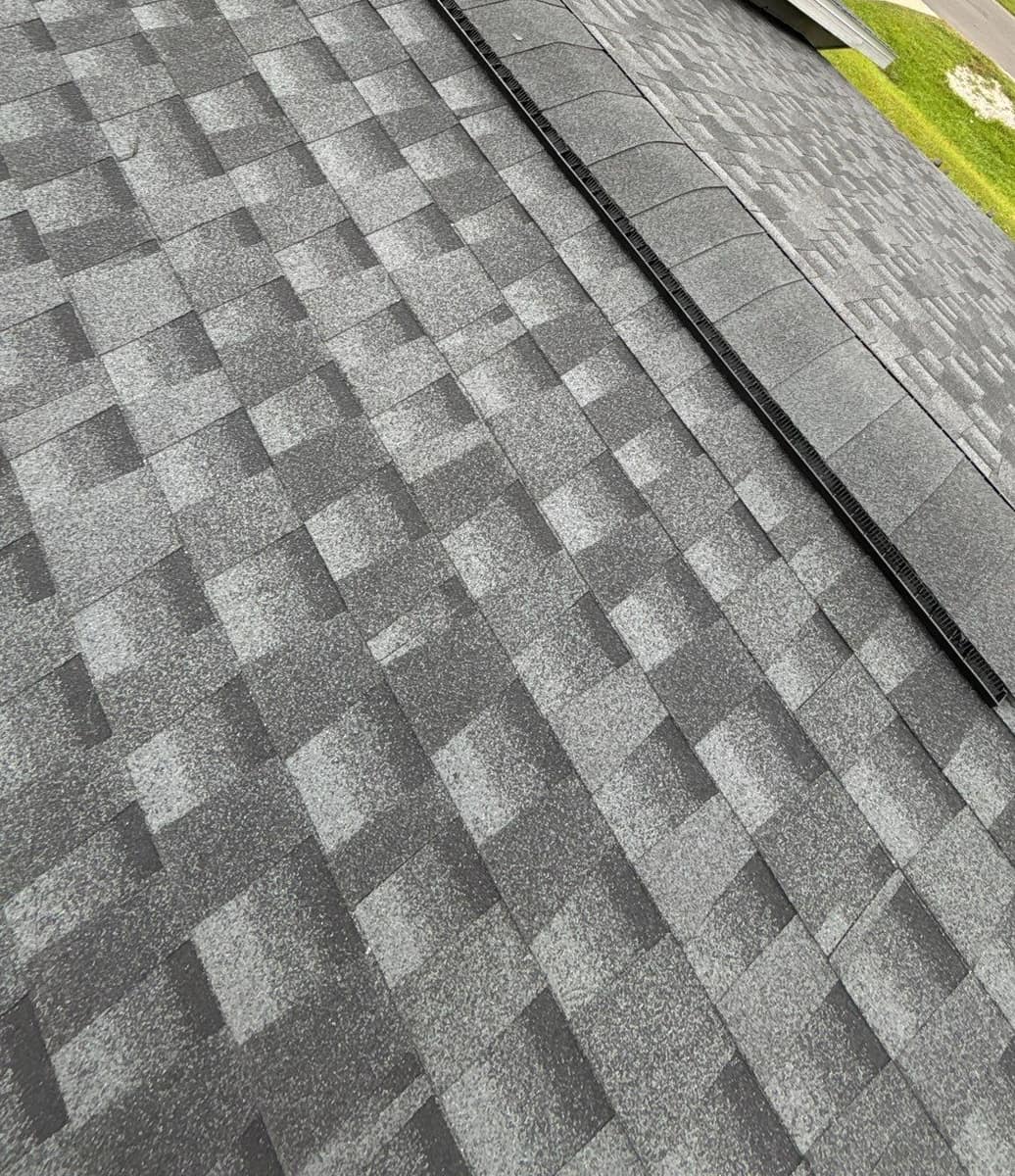 Close view of a ridge vent capped with gray shingles on the new Alachua roof