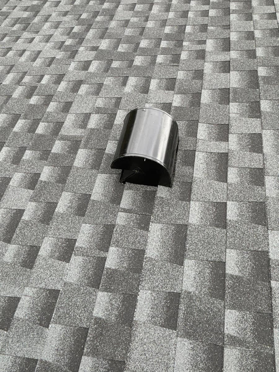 Black half-round hood vent set into the new gray shingles in Alachua