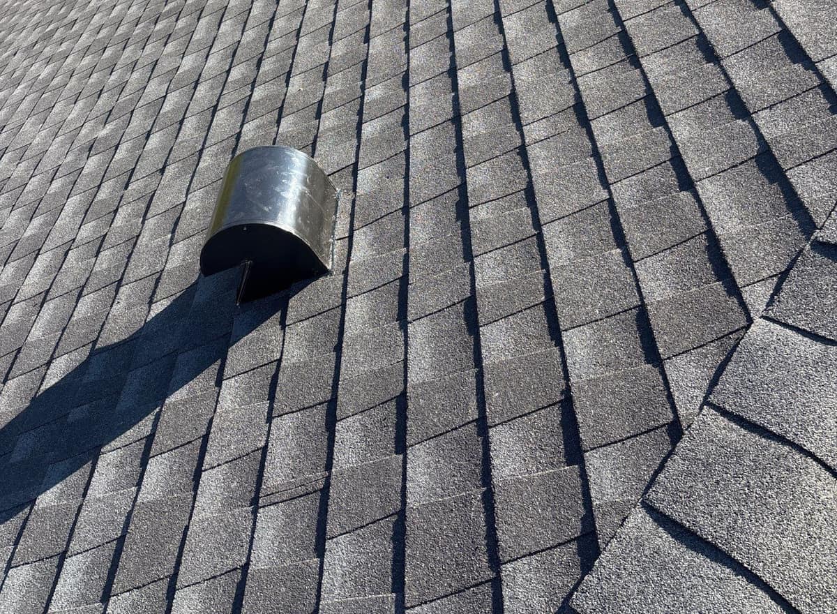 Close view of a metal exhaust hood set into the new shingles on the Alachua roof