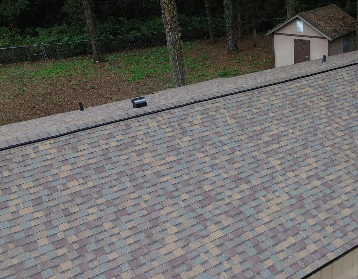 Drone view across the new shingle roof and ridge vent of a ranch home in Alachua