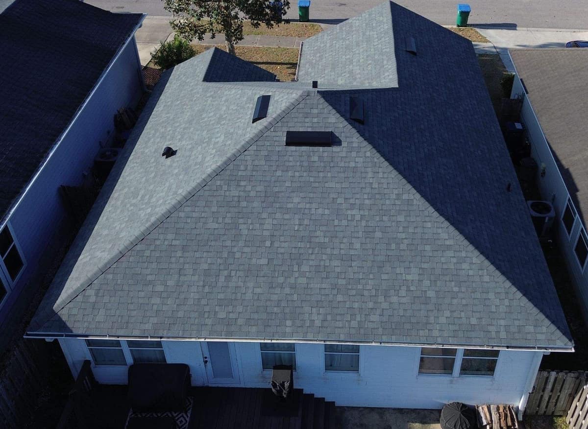 Drone view over the back deck of an Alachua home with a new gray shingle hip roof