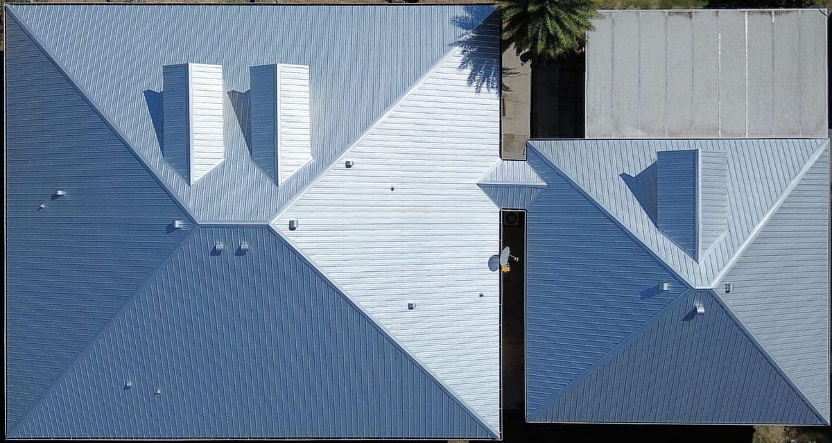 Top-down drone view of the new silver metal roof on an Archer home and its garage wing