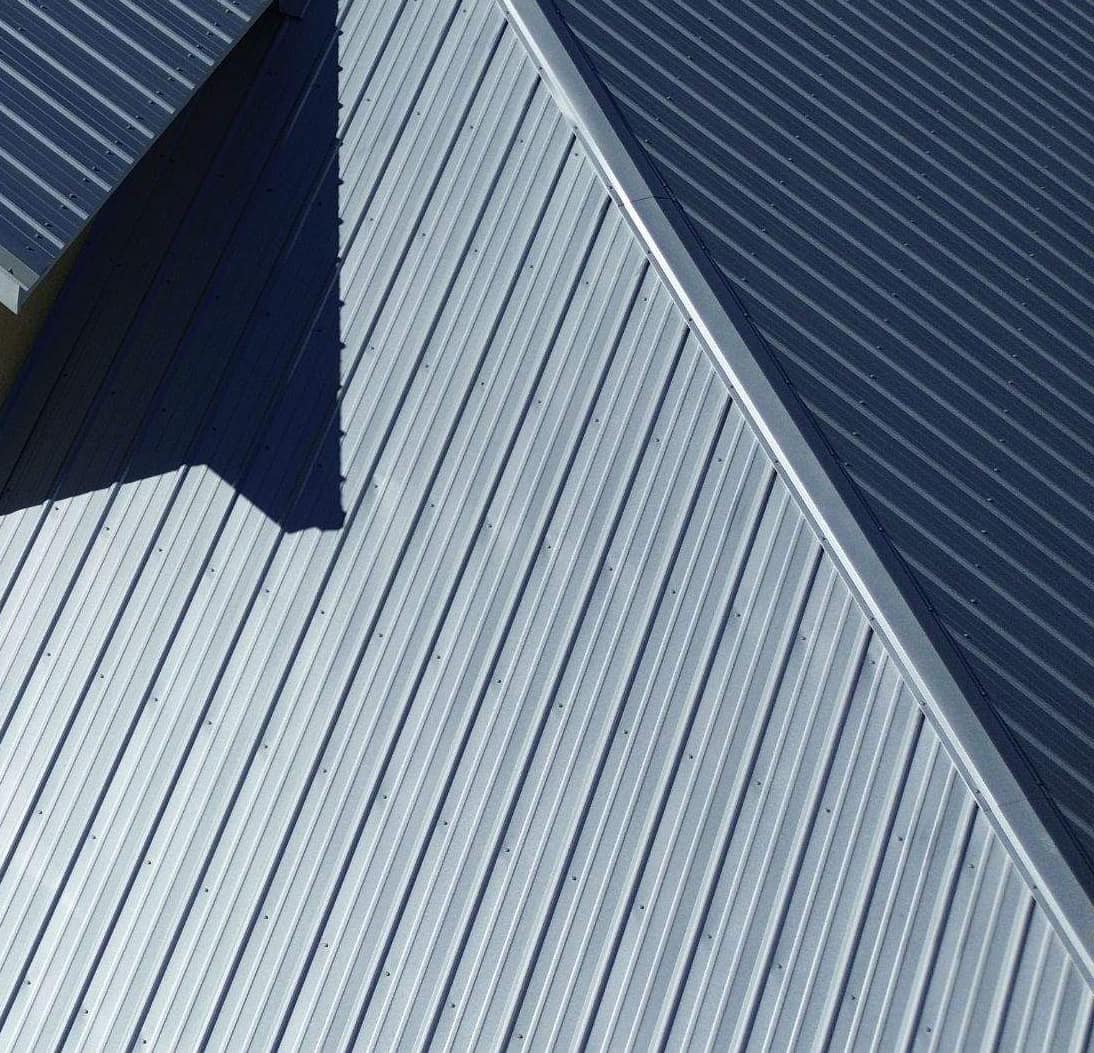Close view of screw rows across the ribbed panels beside a metal hip cap in Archer