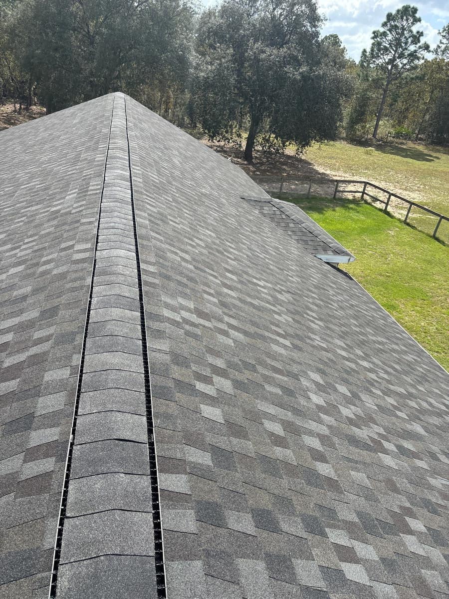 Looking along the new ridge vent and capped ridge of the Archer home toward the oaks