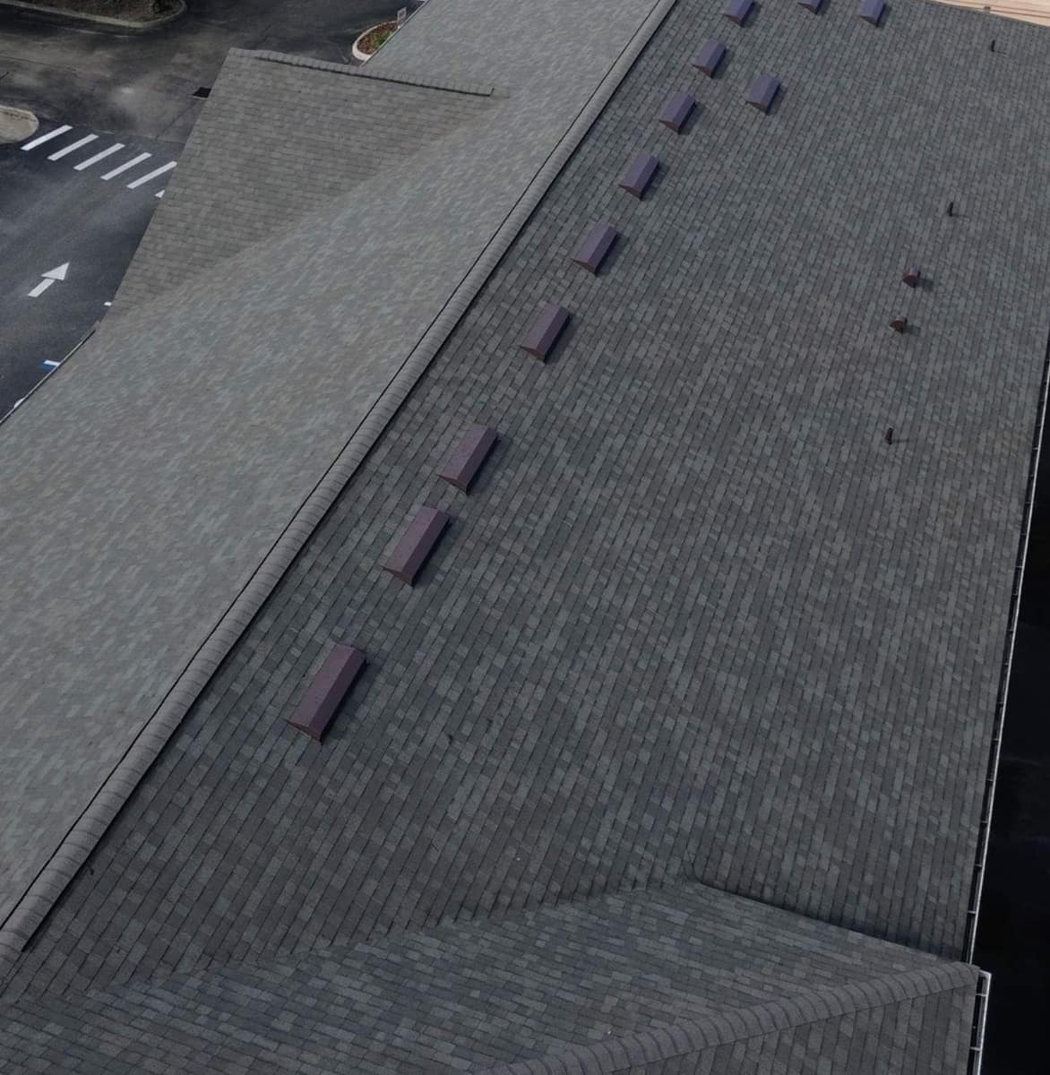Back slope of the Gainesville building with a row of dark red box vents below the ridge