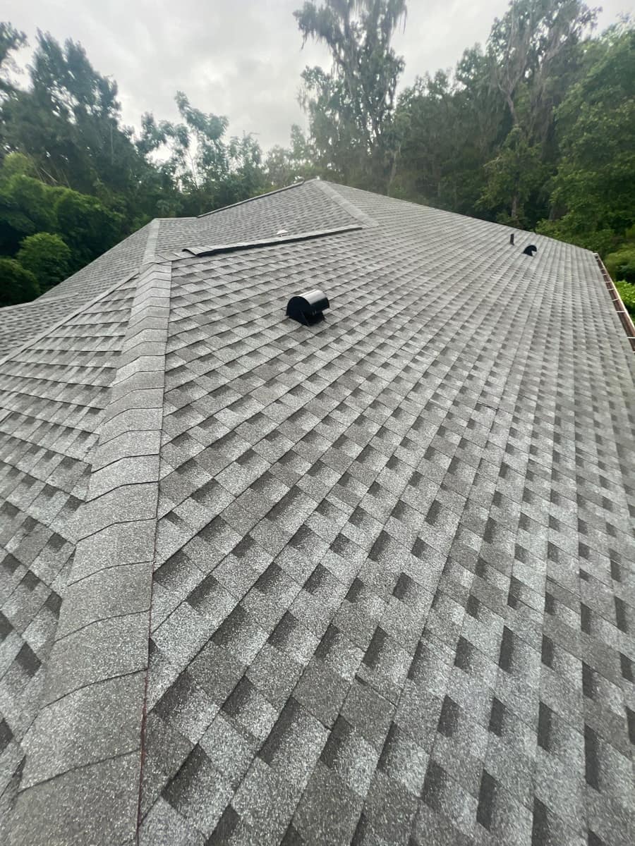 Long slope of the new medium gray shingle roof in Gainesville with hip caps and a hooded vent