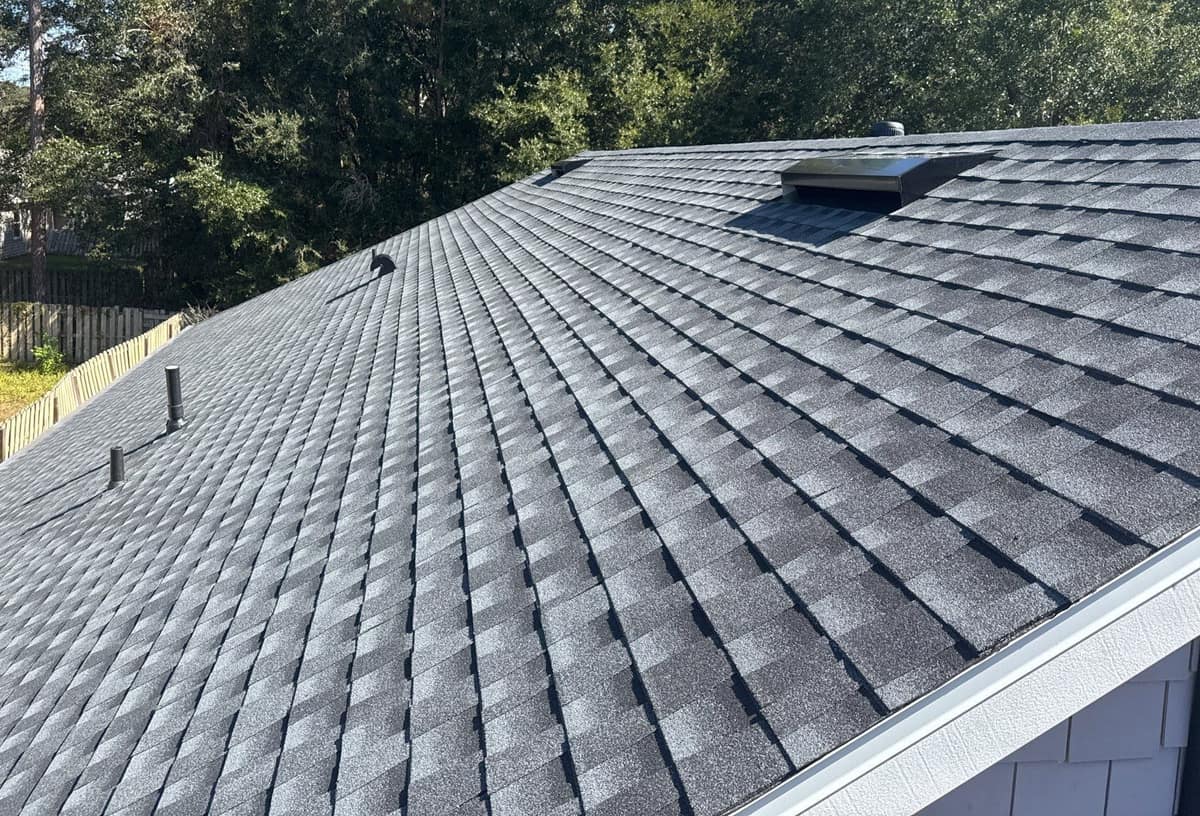 Gray architectural shingles across a long slope of the Gainesville home, with an off-ridge vent near the top
