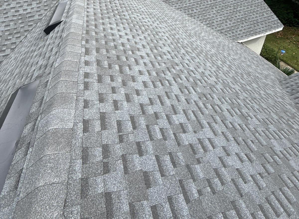 Hip ridge with thick cap shingles and two low black vents beside it in Gainesville