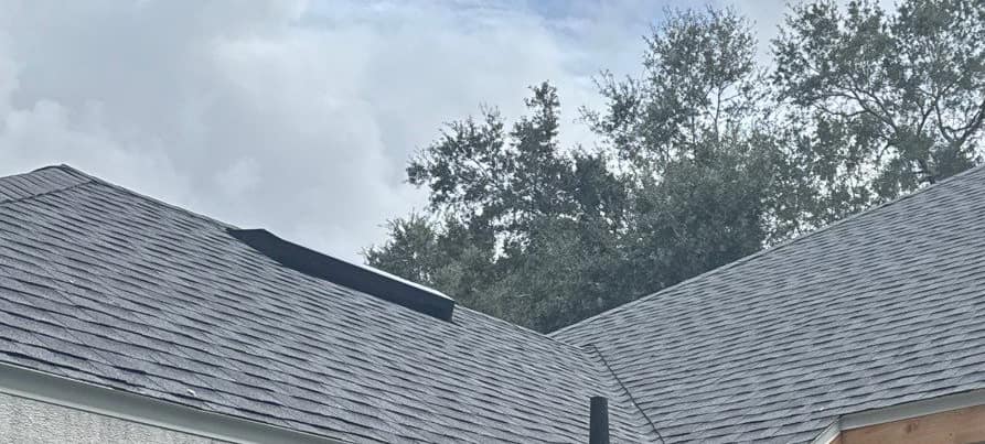 Two roof wings meeting in a valley, with a pipe vent and new fascia boards, in Gainesville