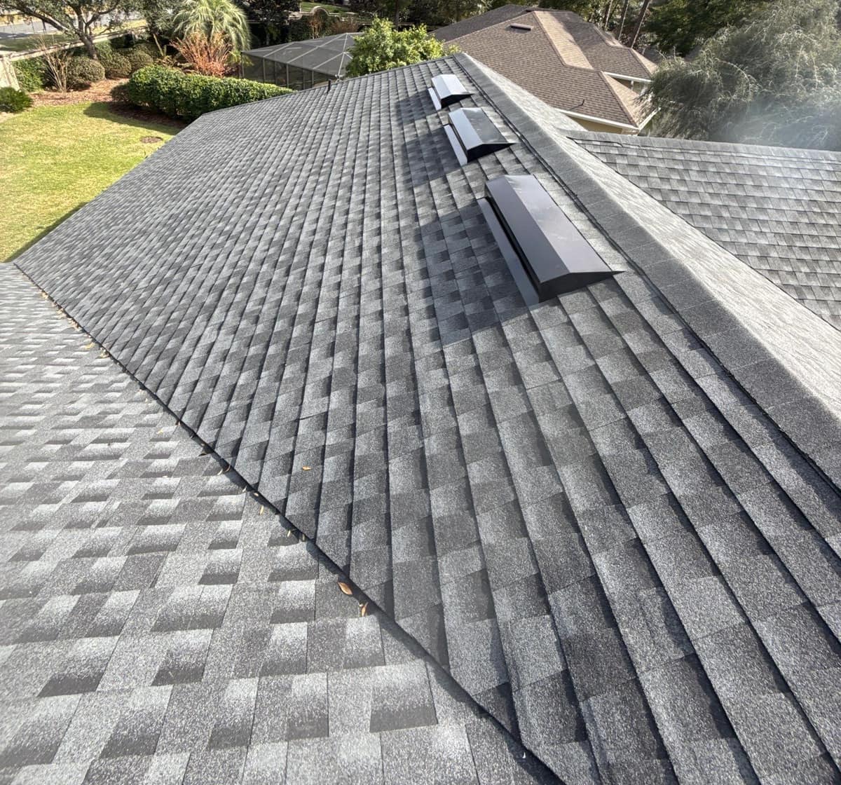 Three long black box vents in a row just below the main ridge of the Gainesville roof