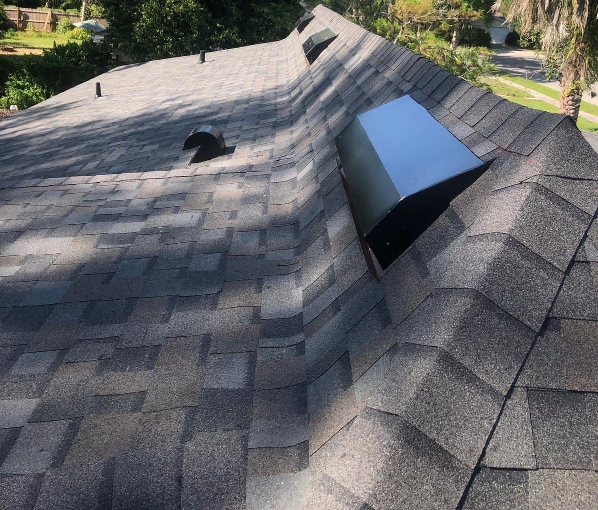 New gray blend architectural shingles and black roof vents across the main roof of a Gainesville ranch home