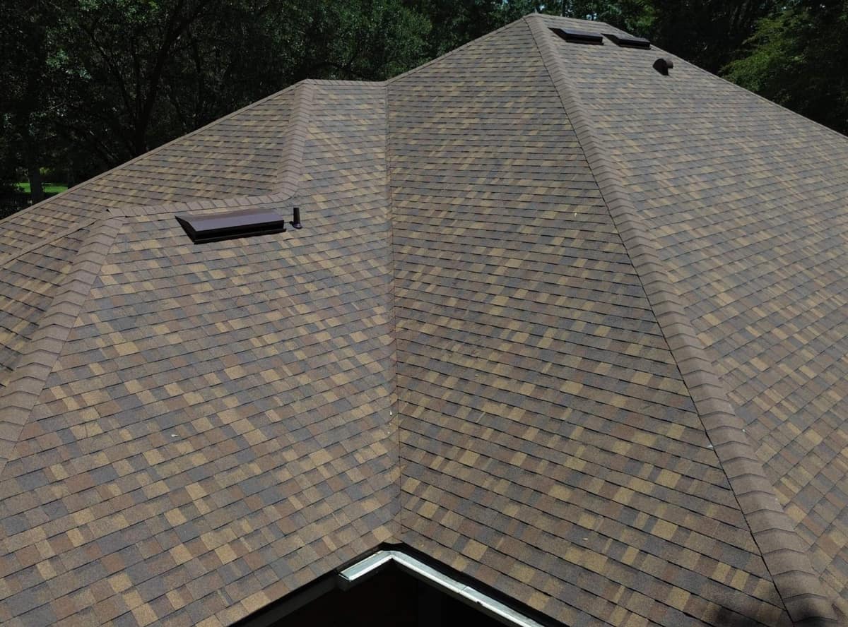 Drone view up the back of the new brown shingle roof on a Gainesville brick home