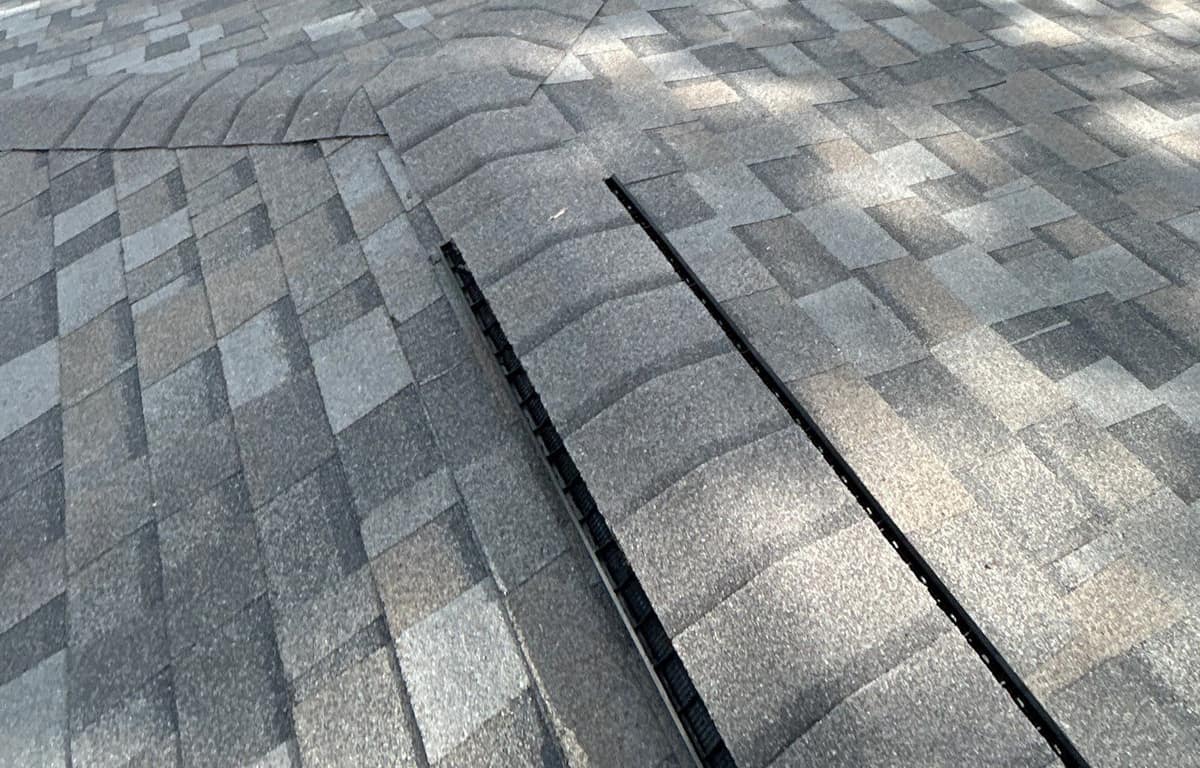 Close view of ridge vent under cap shingles where a ridge meets a hip in Gainesville