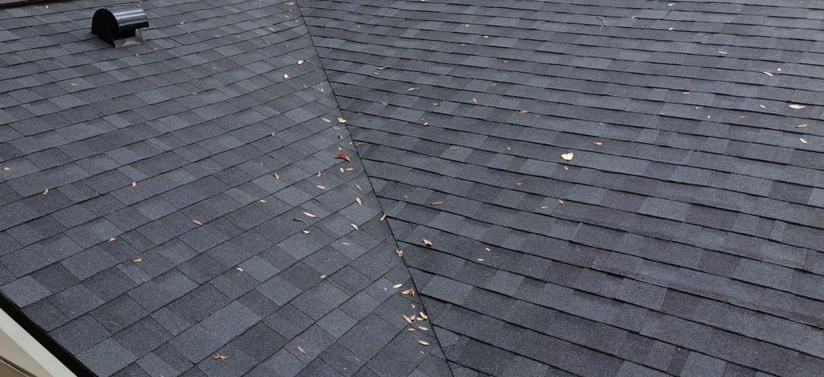 Close view of a closed-cut valley and a black hooded vent on the Gainesville home