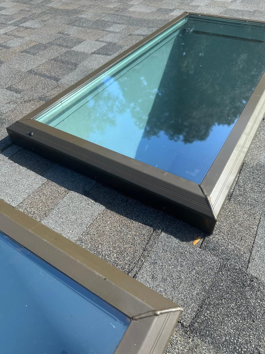 Two skylights with brown frames set into the new shingles on the Gainesville roof