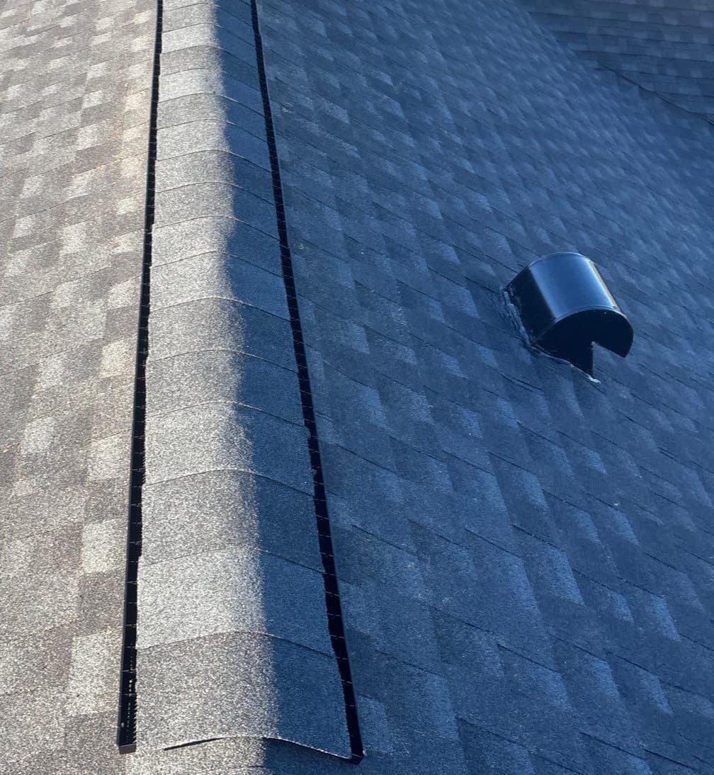 Close view of the ridge vent under cap shingles beside a black hooded vent in High Springs