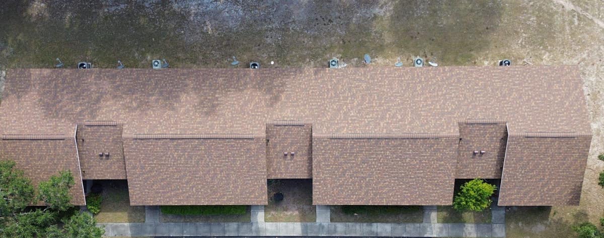 Straight-down drone view of the new brown shingle roof on a long brick building in High Springs