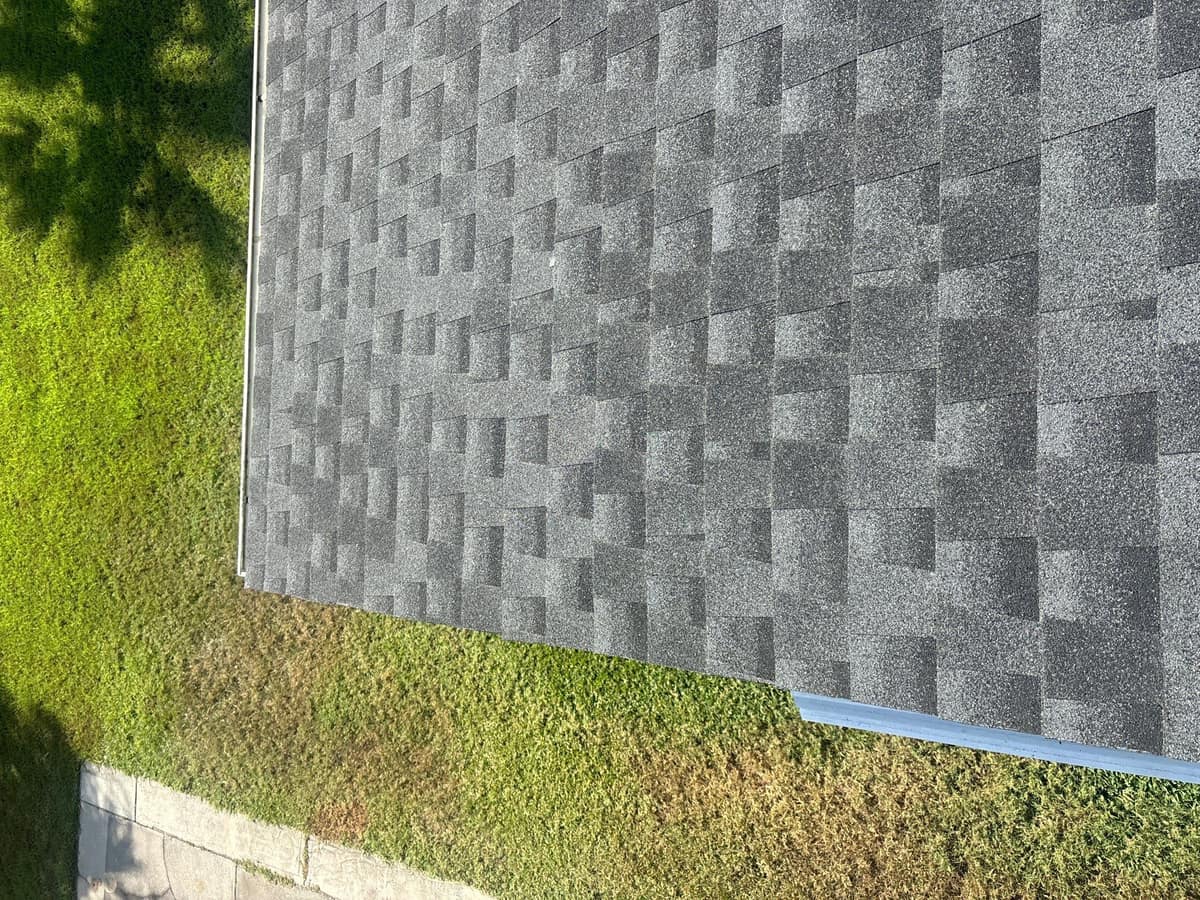 Corner of the new roof with white metal edge trim above the lawn in Lady Lake