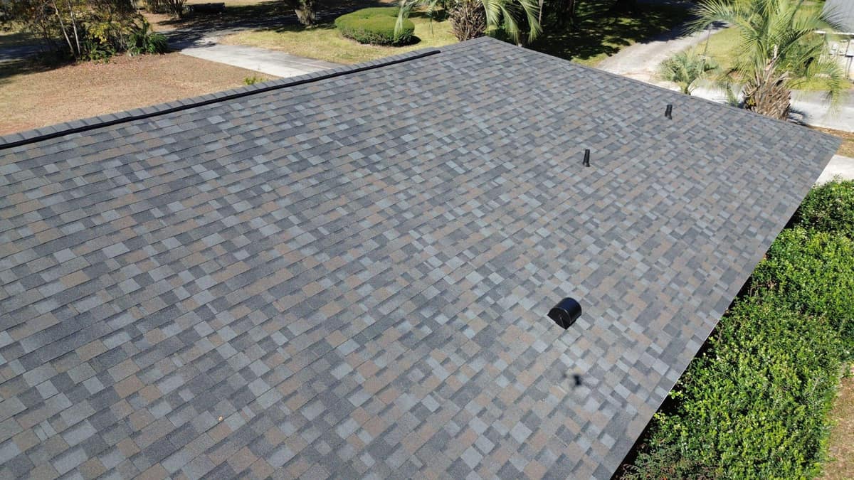 Close look at a black vent hood and two pipe vents on the new Lake City shingles