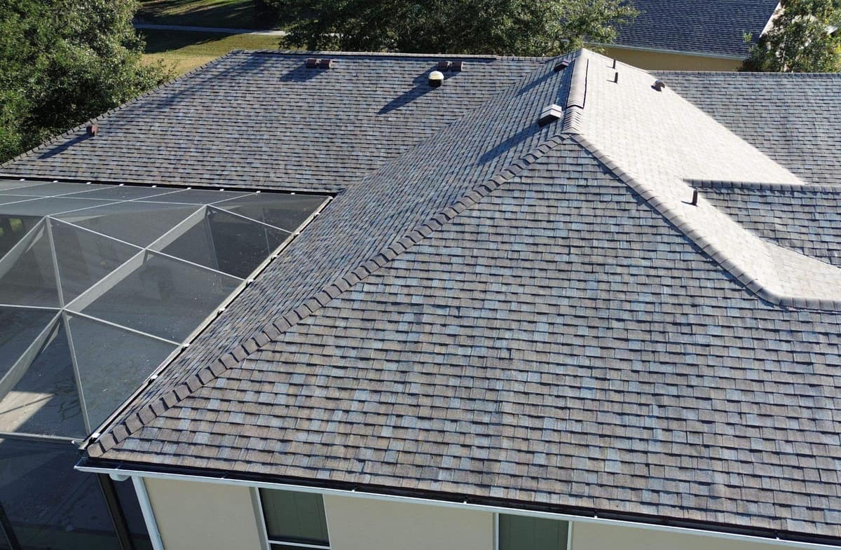 Back slopes of the Leesburg roof with paired brown box vents and cap shingles on the hips