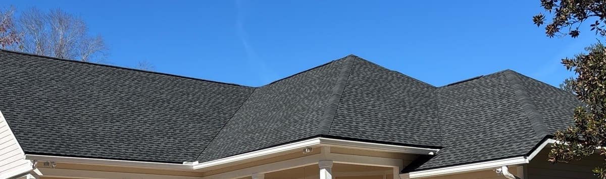 New dark gray shingles on the gable and hip roofs over the back porch of a Newberry home