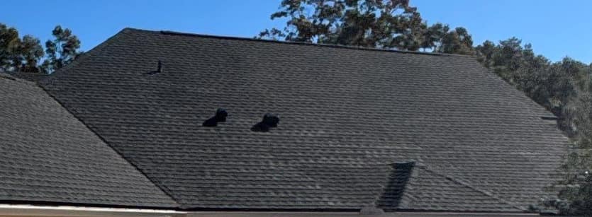 Two black hooded vents and a small pipe vent on the main roof beyond the garage
