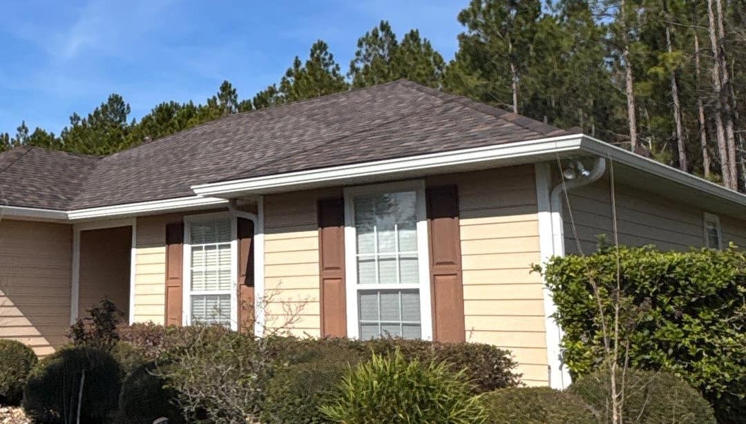 Front of the one-story Newberry home with tan lap siding, brown shutters and the new roof