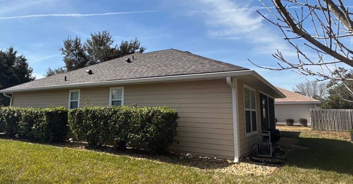 Side wall and screened back porch of the Newberry home under the new shingle roof