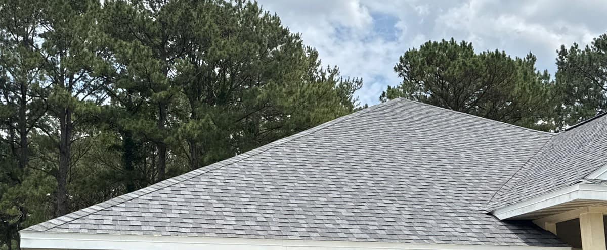 Garage side of the Newberry home, a broad hip roof covered in new gray architectural shingles