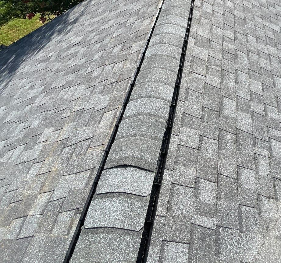 Close view of the ridge vent running under rounded cap shingles on the Newberry roof
