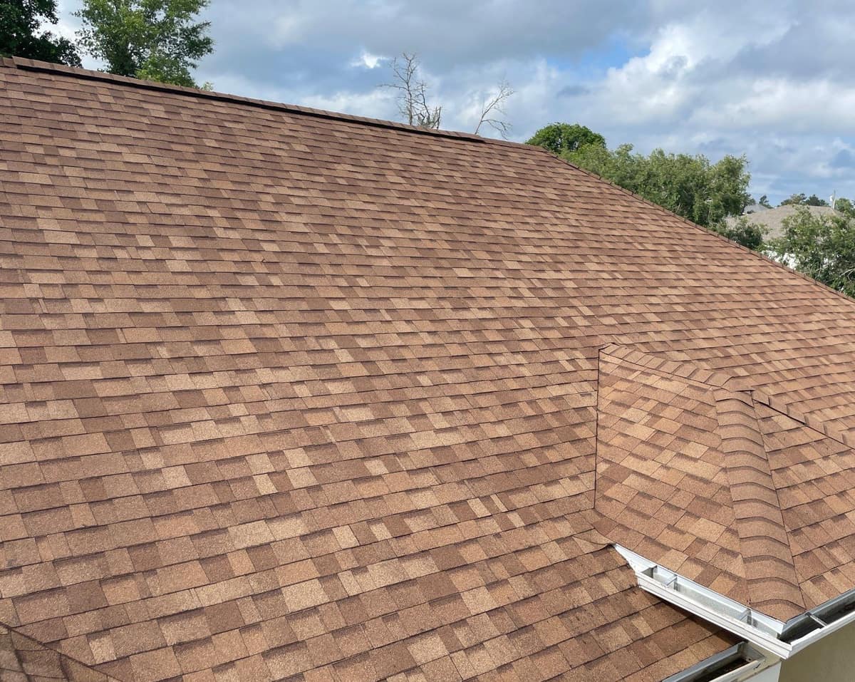New tan and terracotta architectural shingles across the main hip roof of an Ocala home