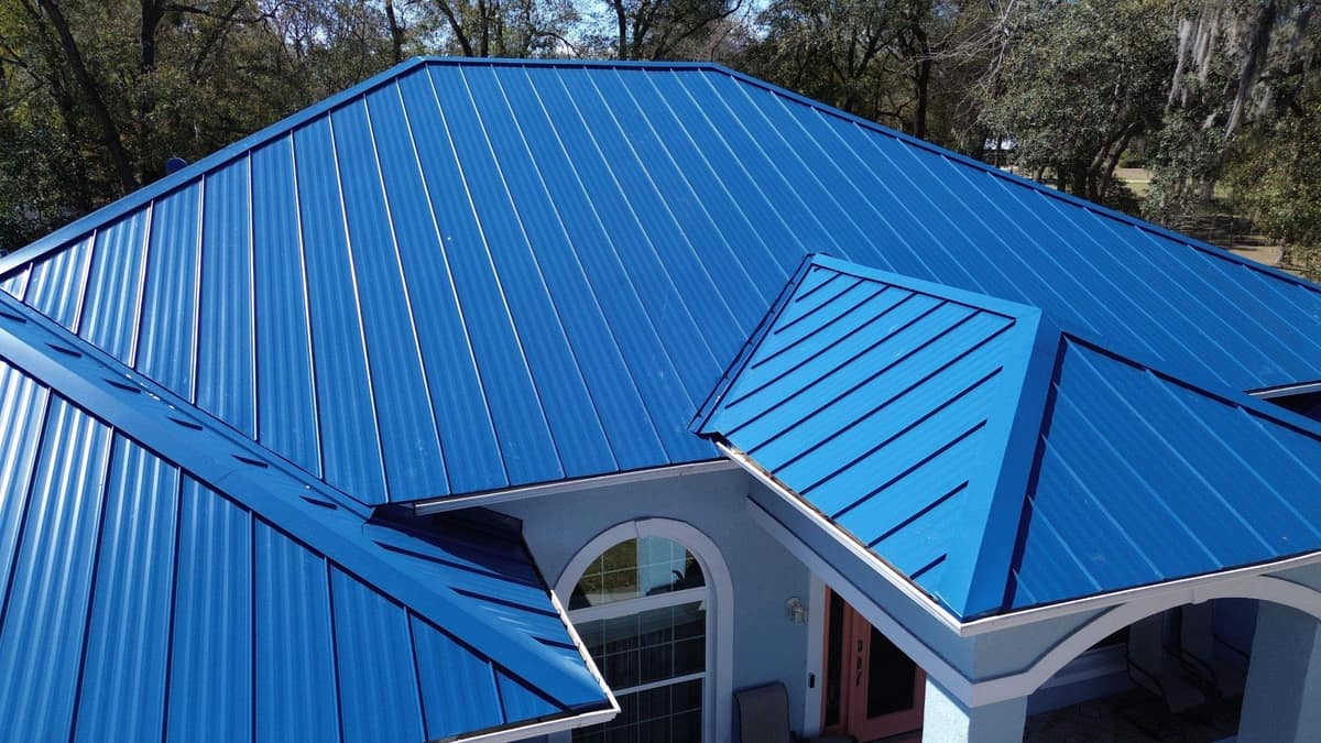 Bright blue standing seam metal roof over the arched entry of a Silver Springs stucco home