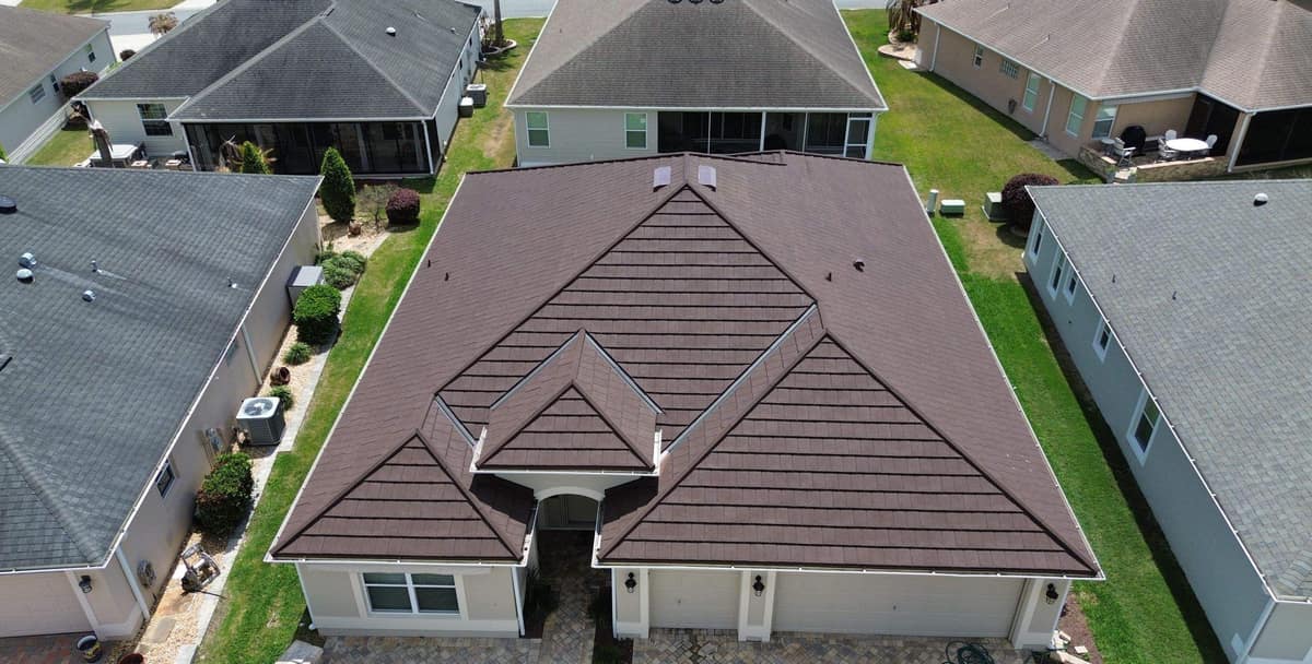 Front of a stucco home in The Villages seen by drone, with a new dark brown metal roof