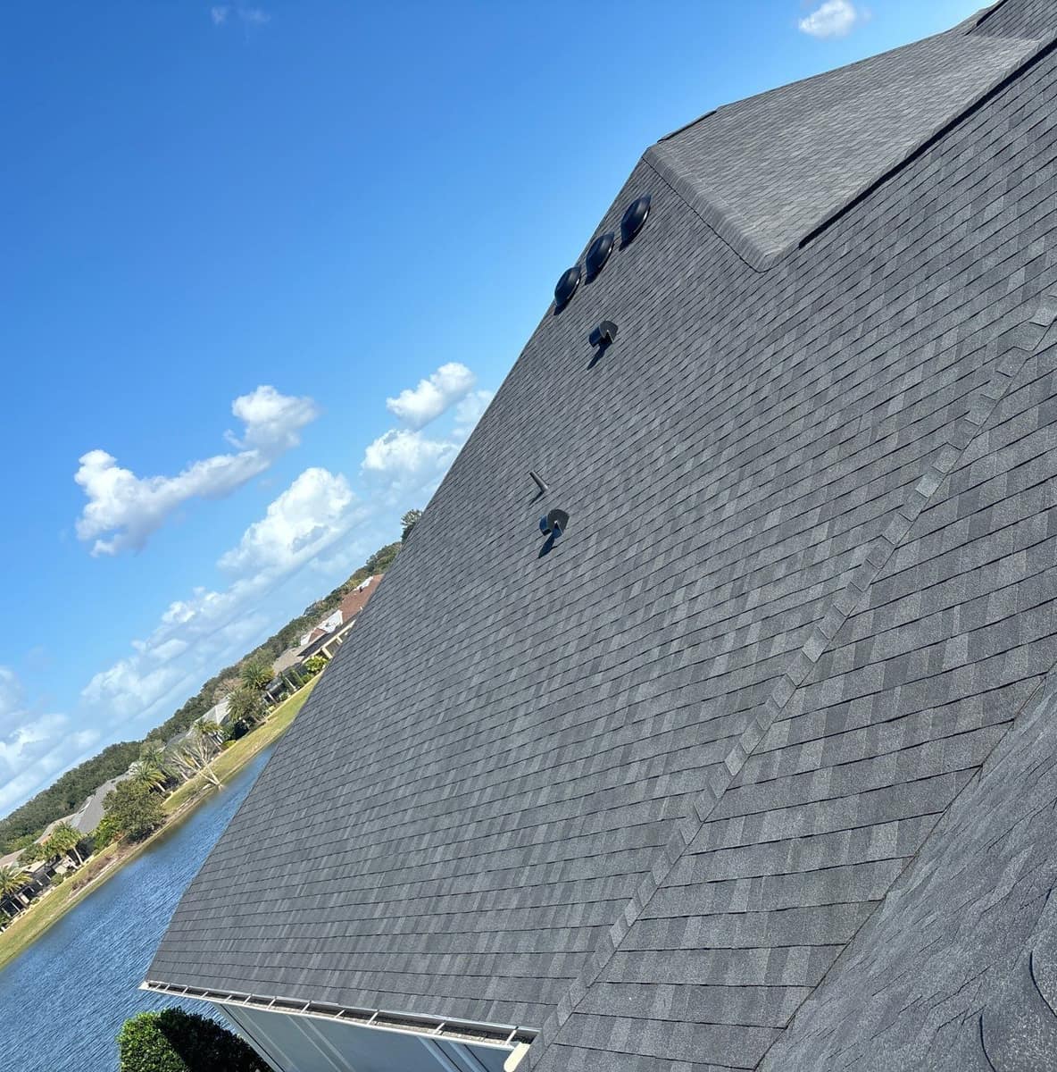 Lake side of a home in The Villages with new dark gray shingles, dome vents and hood vents