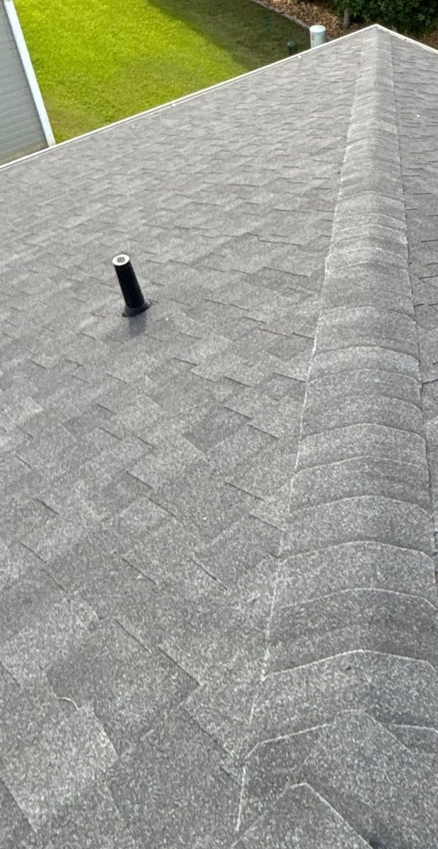 Looking down a hip toward a roof corner past a black vent pipe in The Villages