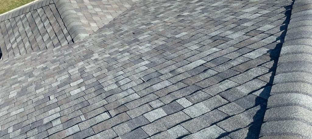 From up on the roof, new shingles slope down to a smaller hip section in The Villages