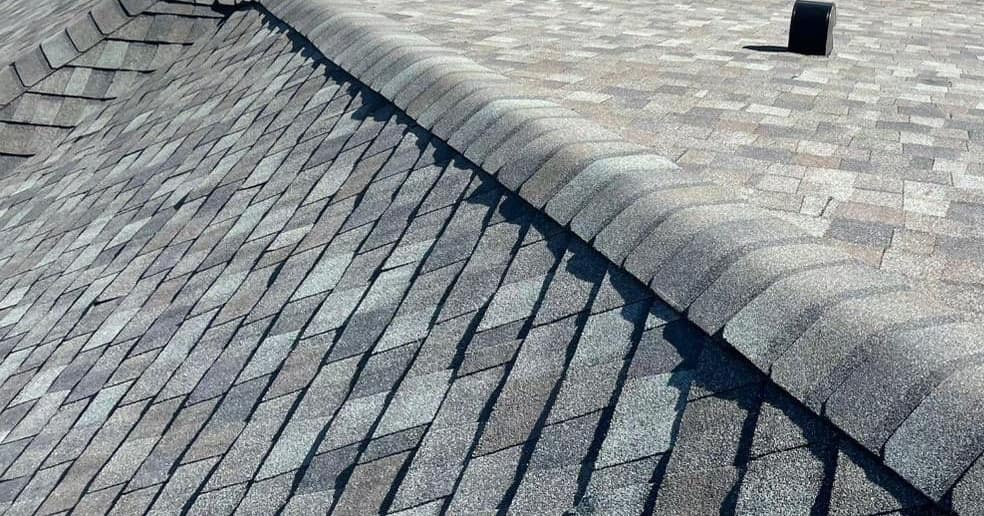 Hip cap shingles running past a black hooded vent on the new roof in The Villages