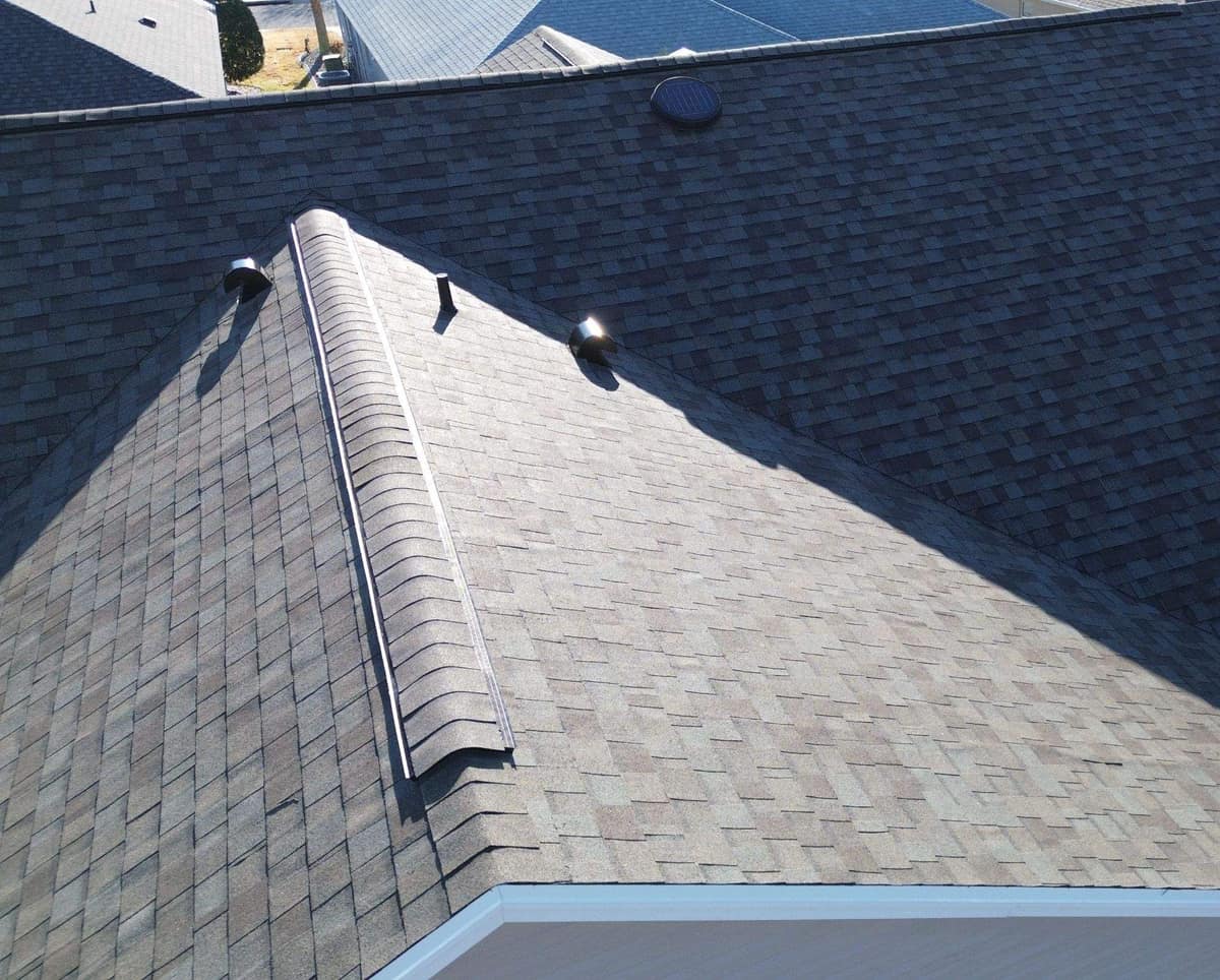 Ridge vent under rounded cap shingles on the garage wing of the home in The Villages
