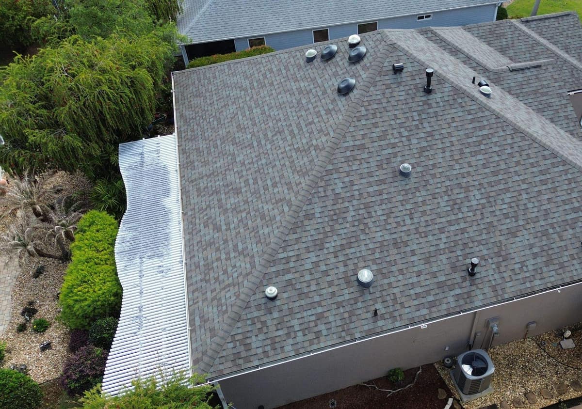 Drone view of the new gray blend shingle hip roof on a single-story stucco home in The Villages