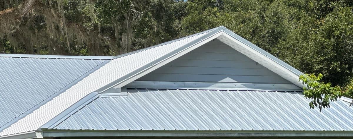 Front gable wing in Trenton with white trim and a lower band of ribbed metal below it