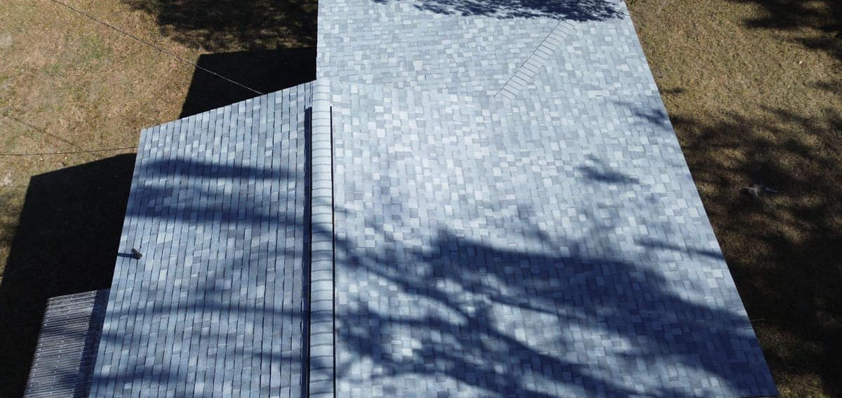 Overhead drone view of the new light blue-gray shingle roof on a Williston country home